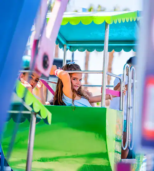 Niña en la noria infantil de Pola Park, parque de atracciones de Santa Pola